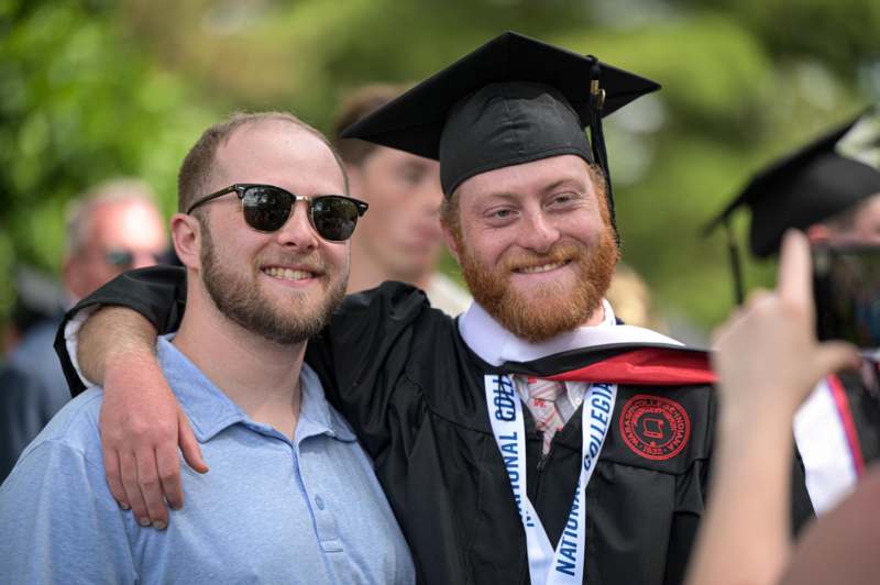a man in a cap and gown with his arm around another man
