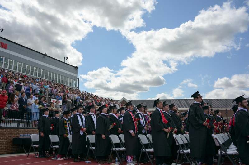 a group of people in graduation gowns and caps standing in a row
