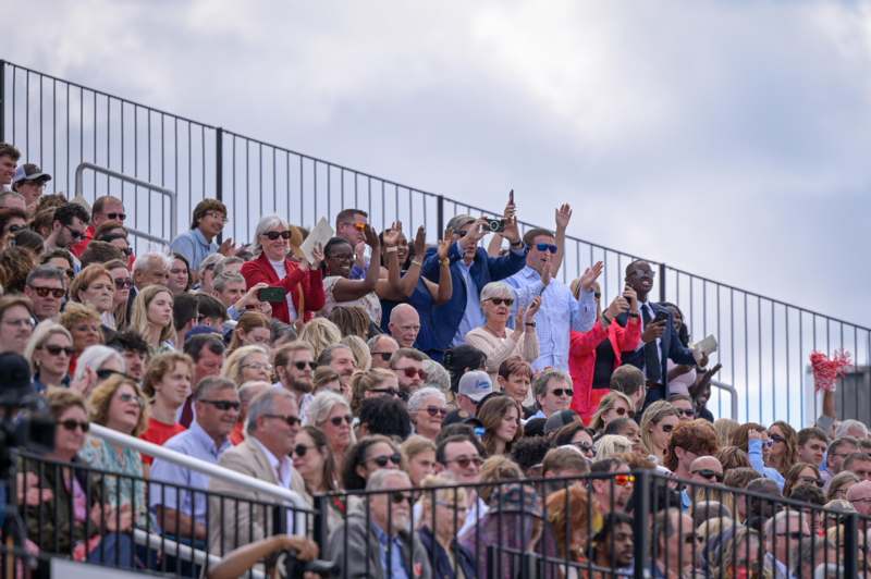 a crowd of people standing on a bleachers