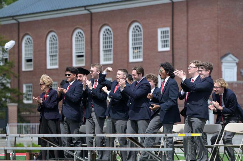 a group of people in suits and ties clapping