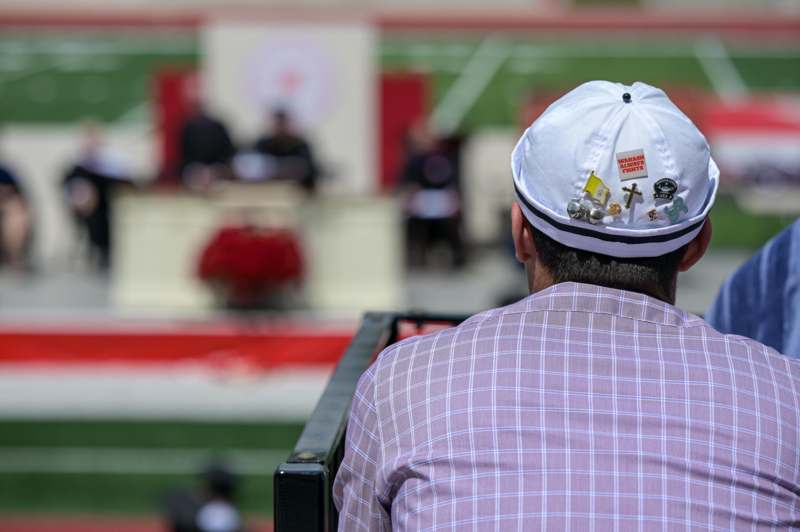 a man wearing a white hat with pins on his head