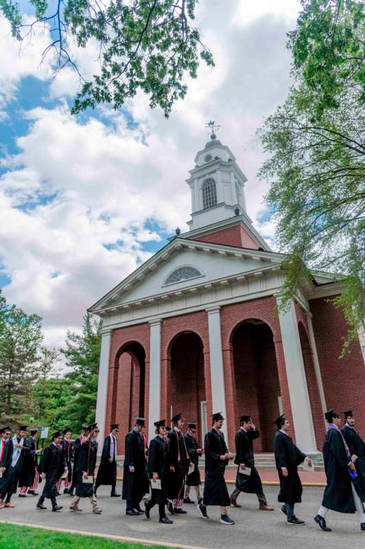 a group of people in graduation gowns outside a building