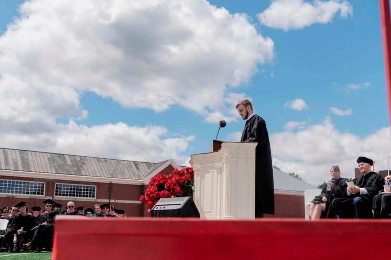 a man in a robe standing at a podium
