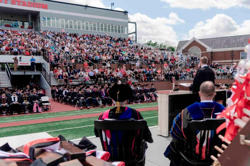 a group of people in black graduation gowns and hats