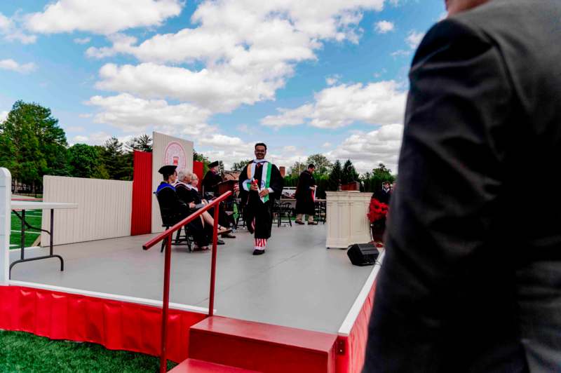 a man in a graduation gown on a stage