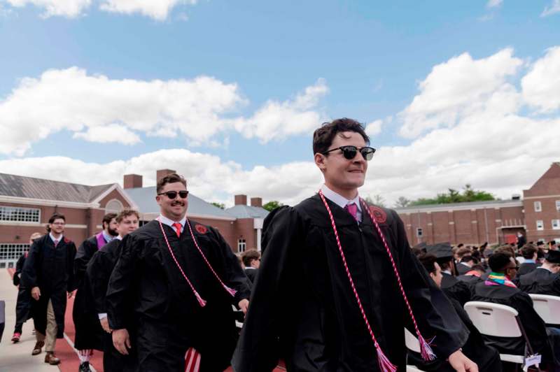 a group of men in graduation gowns and caps