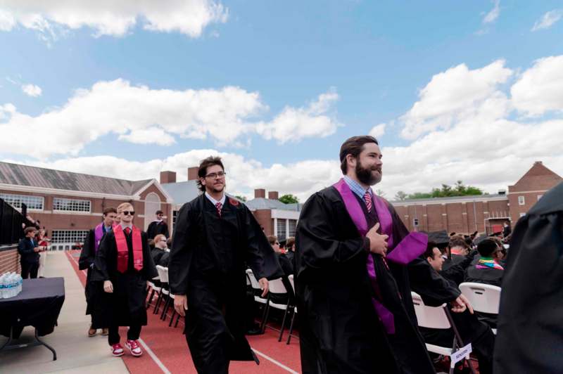 a group of people in graduation gowns and sashes