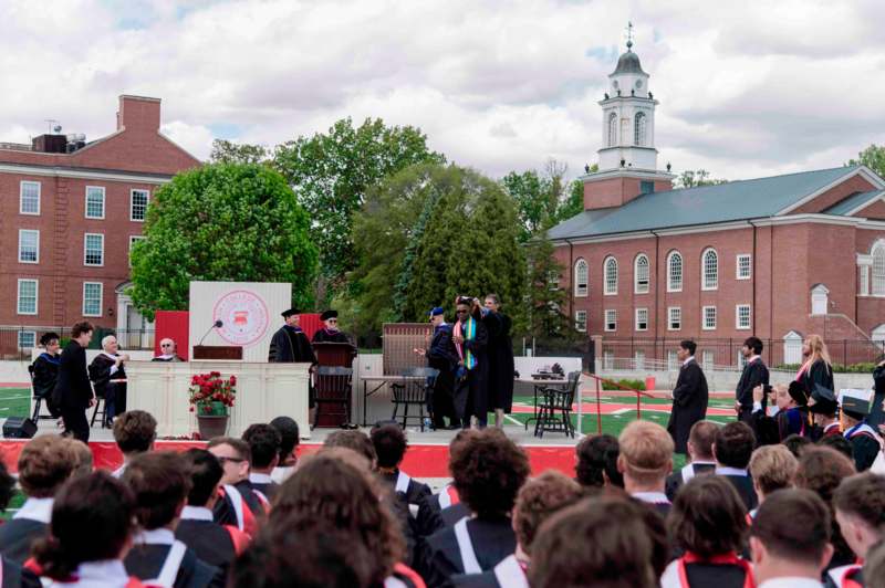 a group of people standing on a stage in front of a large group of people