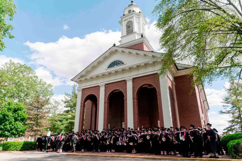 a group of people in graduation gowns and caps outside of a building