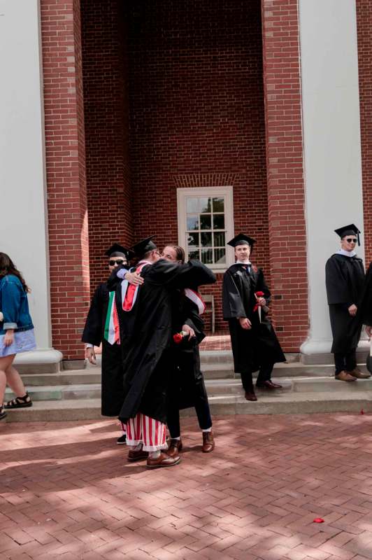 a group of people in graduation gowns hugging