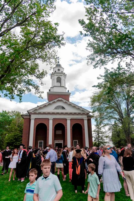 a group of people in graduation gowns outside a building