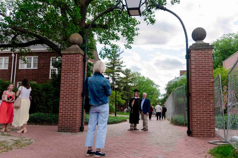 a group of people standing under a brick archway