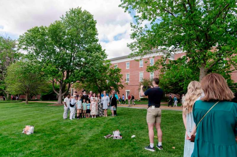 a group of people standing in a grassy area
