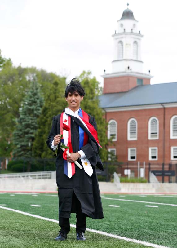 a man in a graduation gown holding a ribbon