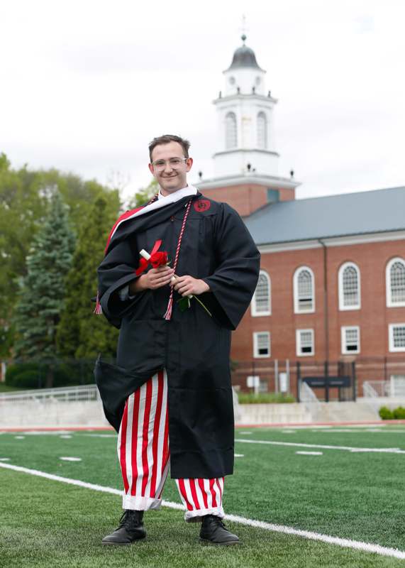 a man in a black robe holding a red rose and a white rose