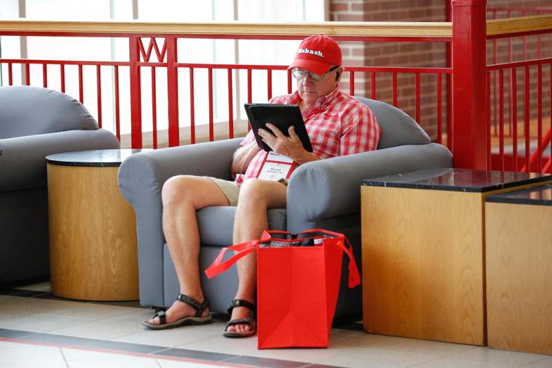 a man sitting in a chair with a tablet