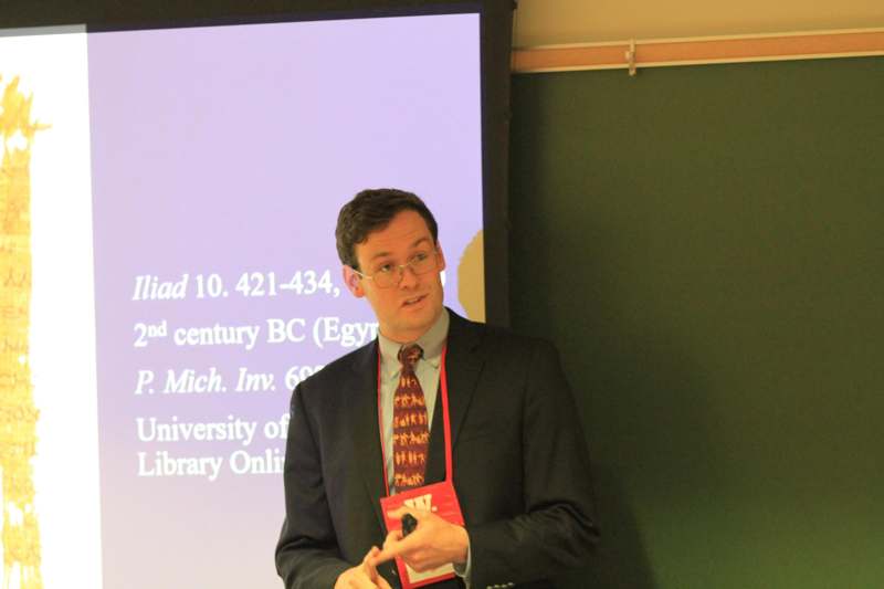 a man in a suit standing in front of a chalkboard