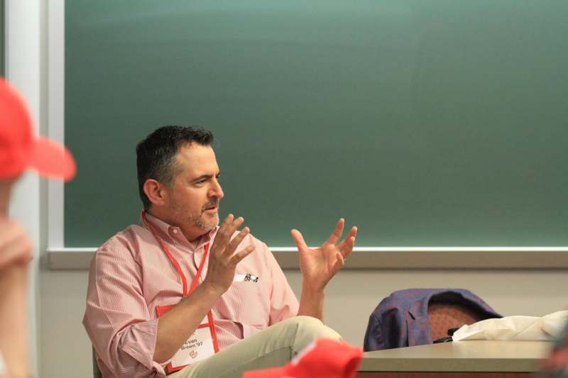 a man sitting in front of a chalkboard