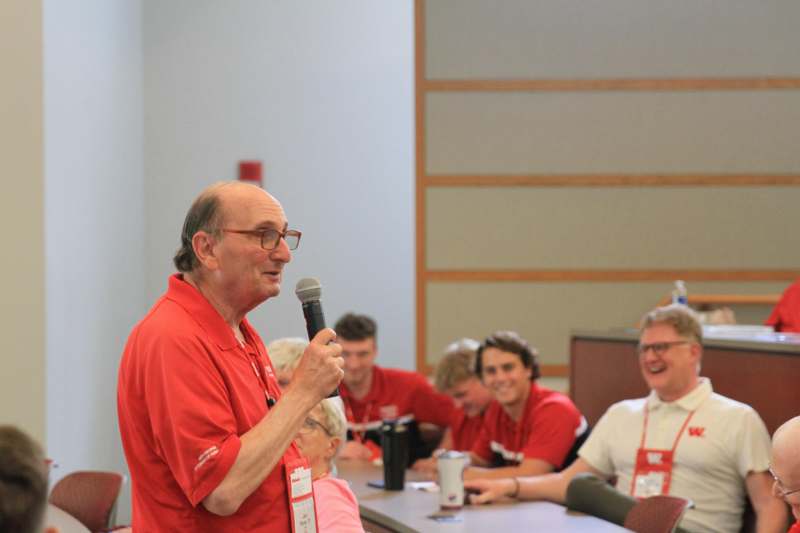 a man in red shirt speaking into a microphone