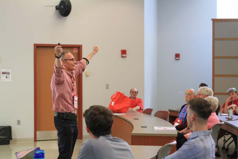 a man holding a microphone in front of a group of people
