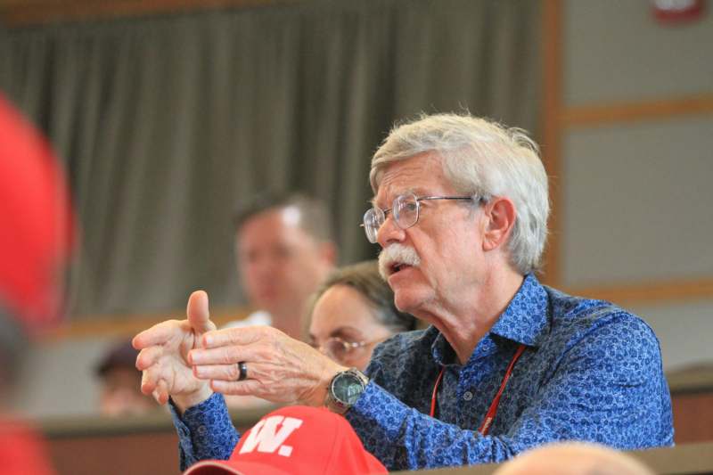 a man with a mustache pointing at something