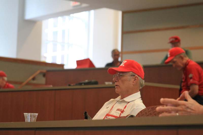 a man in a red hat sitting in a courtroom