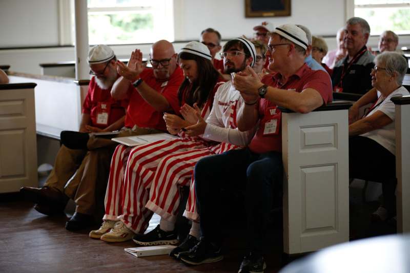 a group of people in red and white striped pants clapping