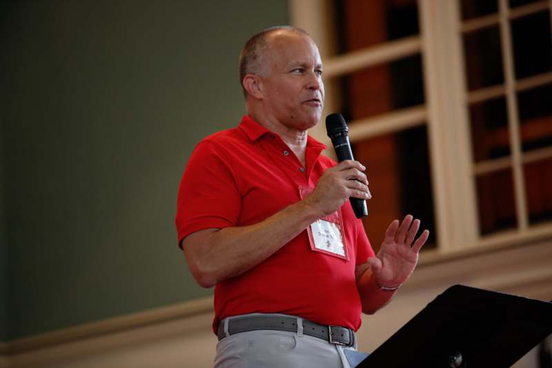 a man in a red shirt holding a microphone