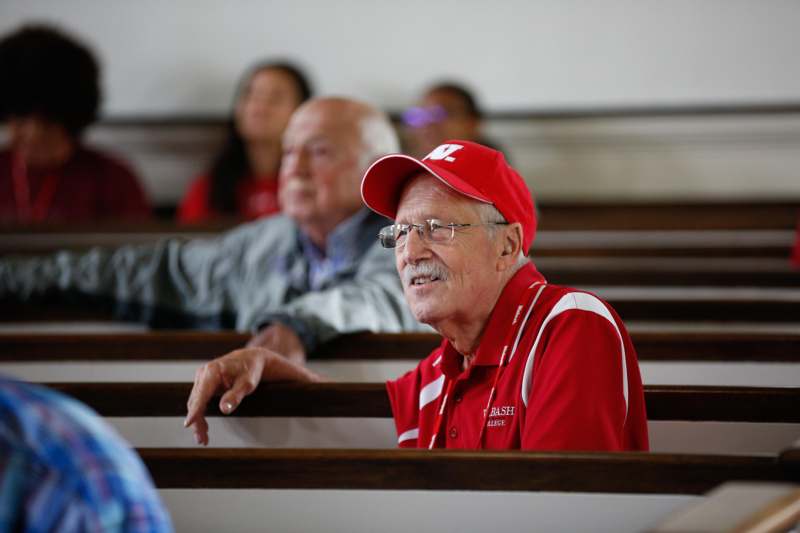 a man in a red hat sitting in pews