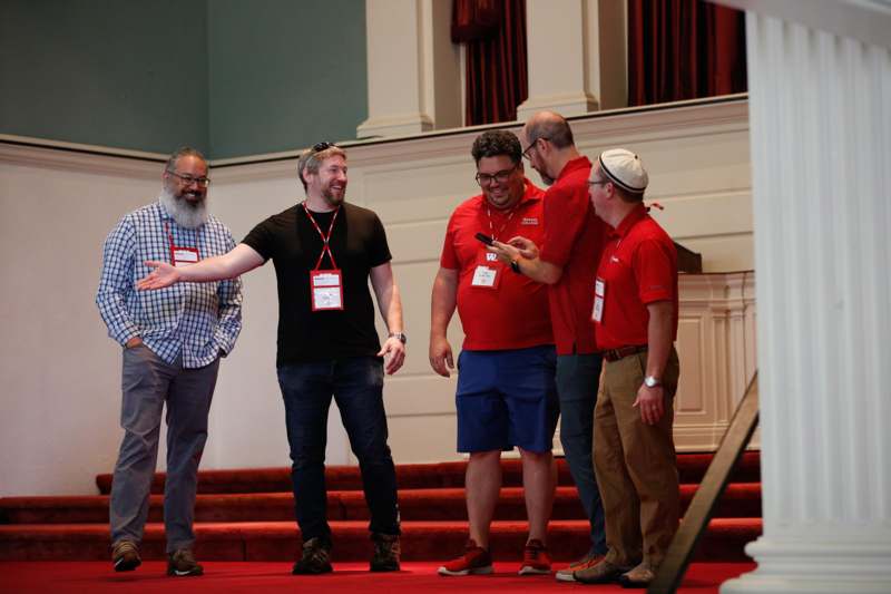 a group of men standing on a red carpet