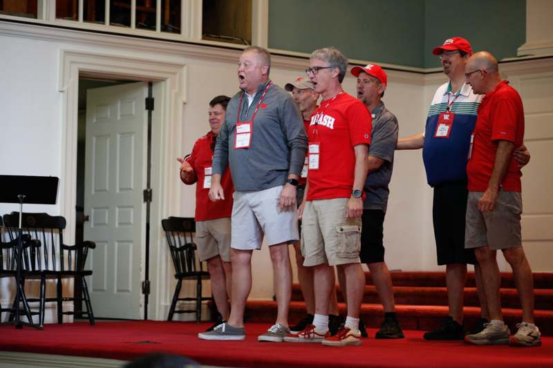a group of men singing on a stage