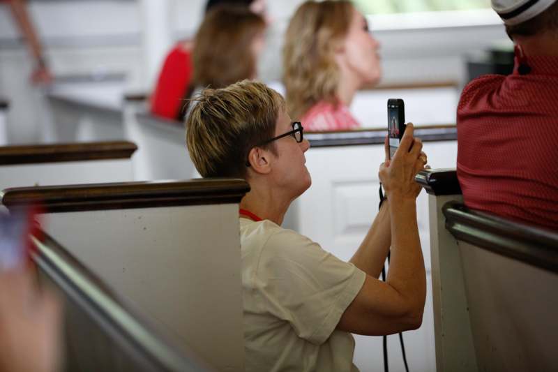 a woman taking a picture of a person in a church