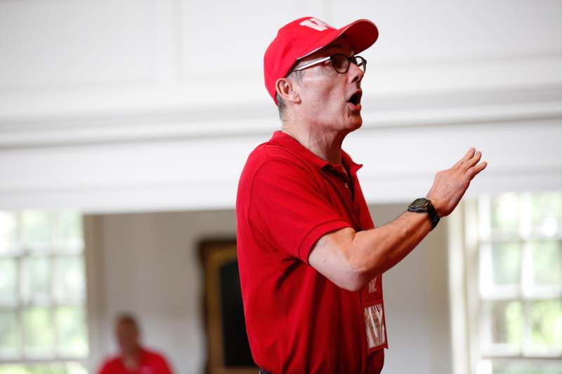 a man in red shirt and cap speaking