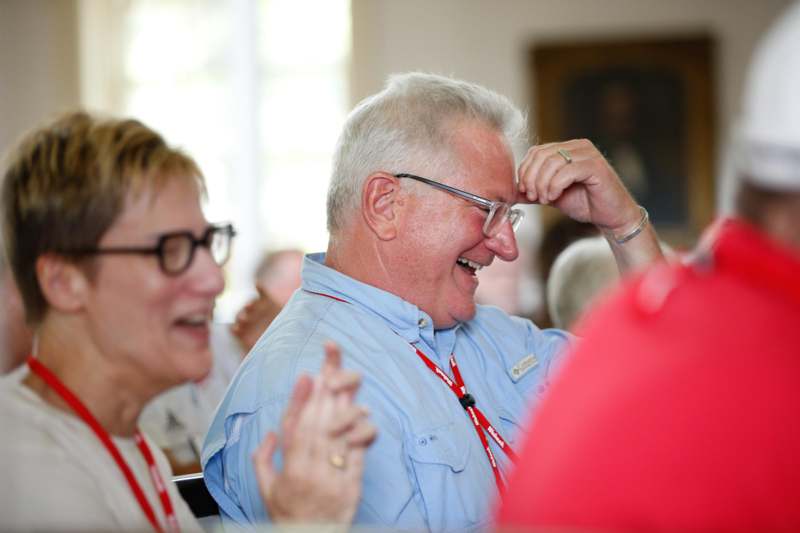 a man laughing with his hand on his head
