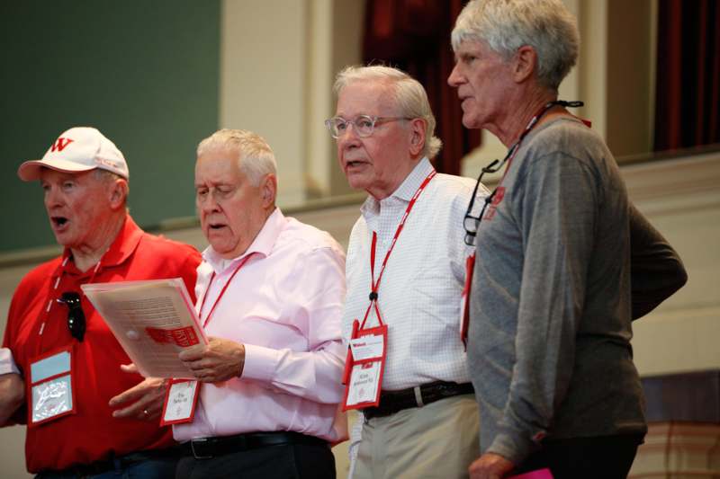 a group of old men standing in a room