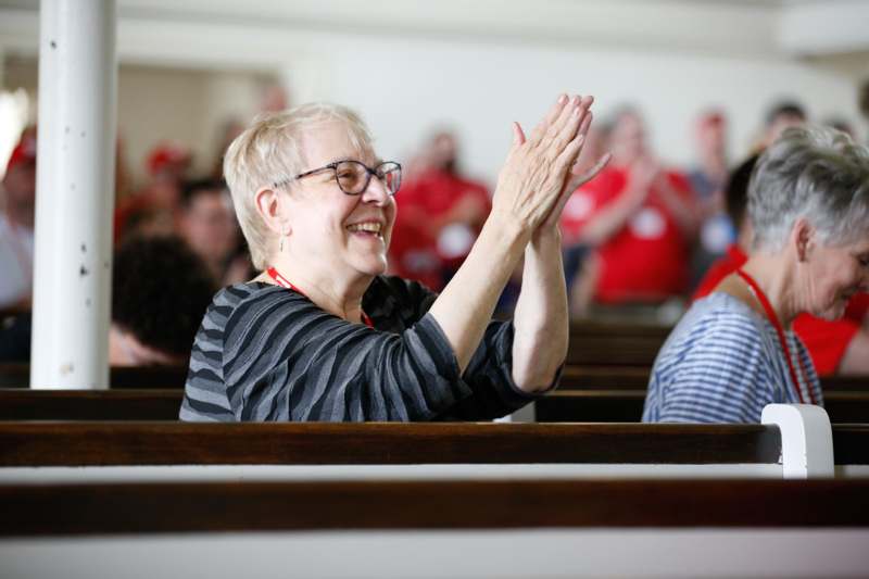 a woman sitting in pews with hands together