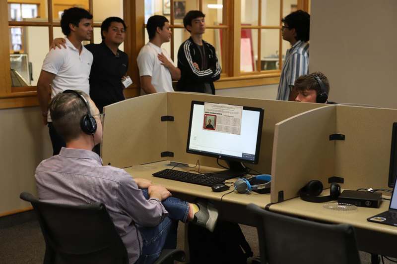 a group of people around a computer