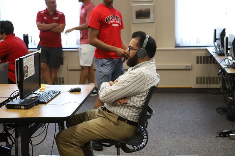 a man sitting at a desk wearing headphones