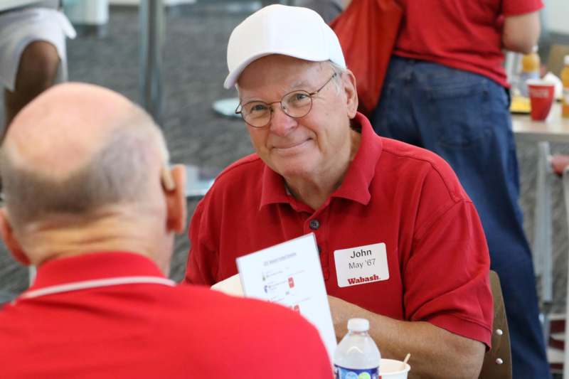 a man in a white cap and red polo shirt