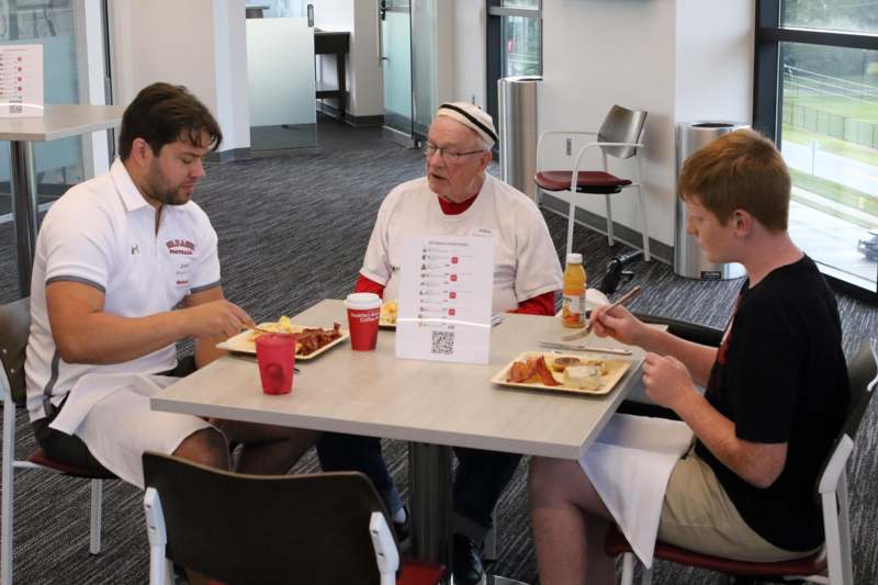 a group of people sitting at a table eating food