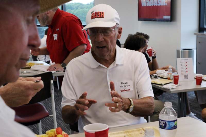 a man in a white hat talking to a group of people