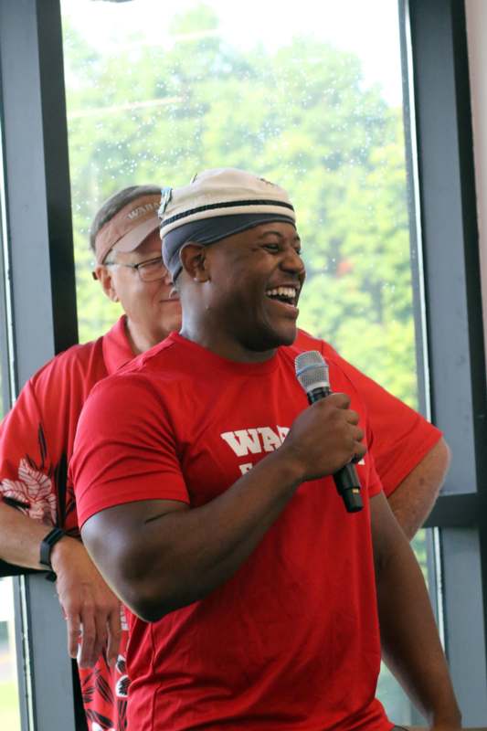 a man in red shirt holding a microphone