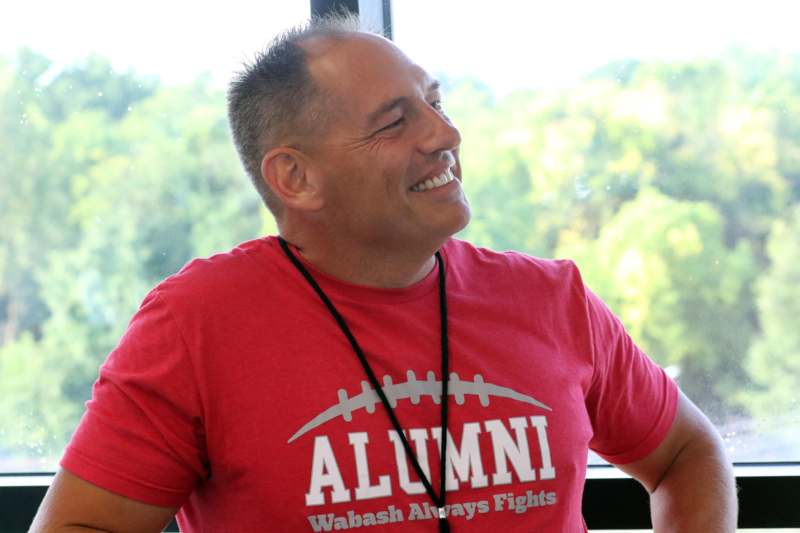 a man smiling with a red shirt