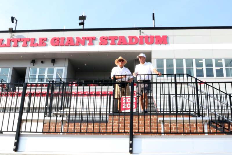 men standing on a railing in front of a building