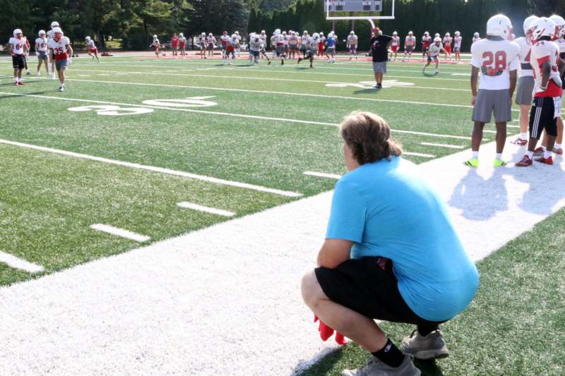 a man squatting on a football field