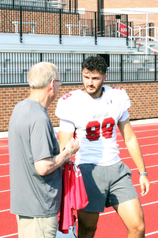 a man talking to a football player