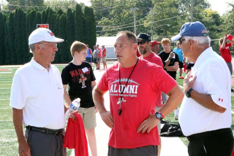 a group of men talking on a field