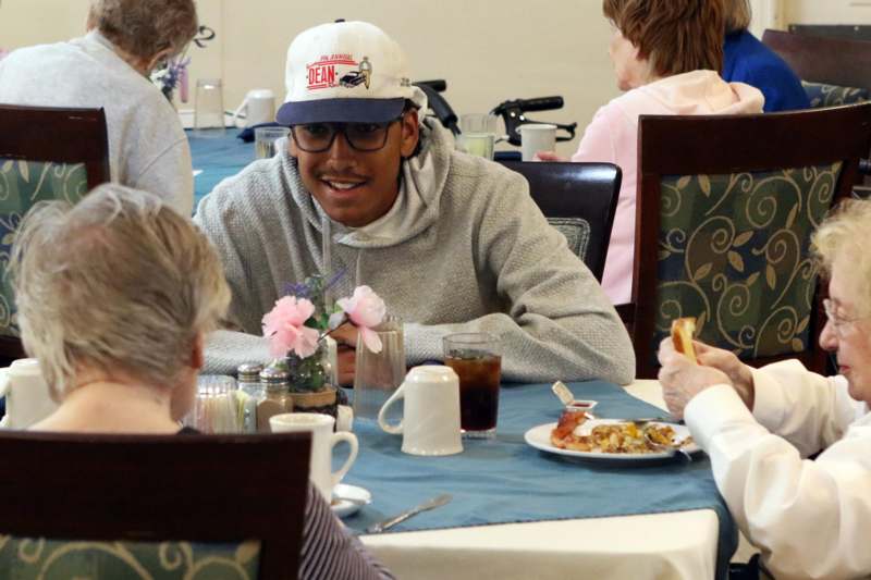 a man sitting at a table with a woman eating