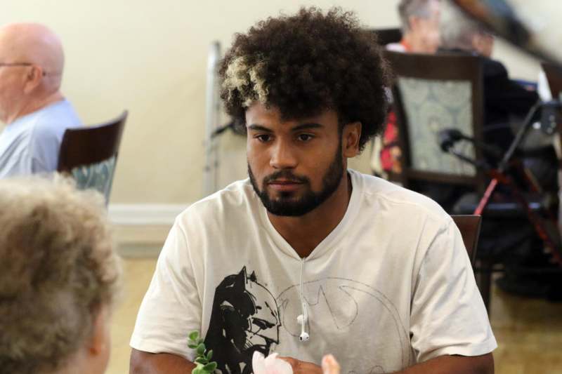 a man with curly hair sitting in a chair