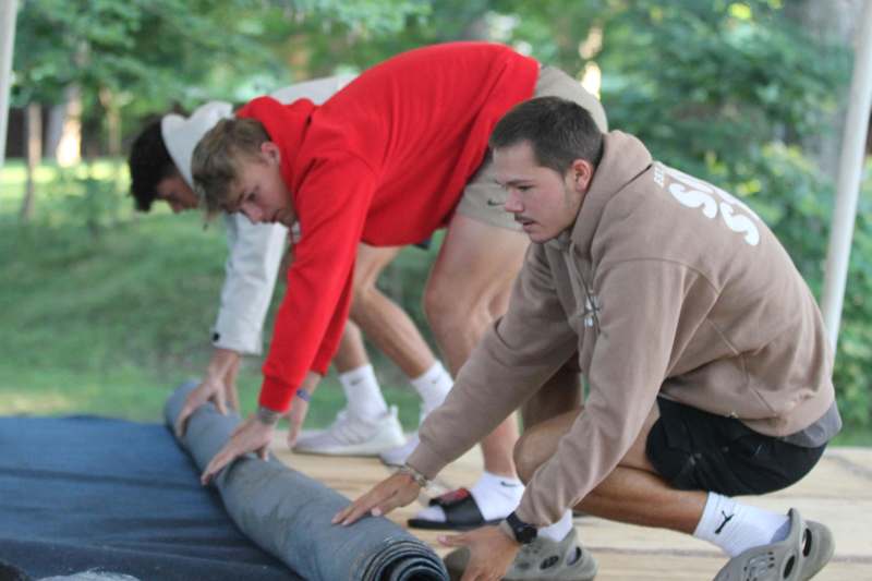 a group of men rolling a carpet